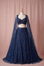 Navy blue sequin two-piece outfit on a mannequin against a pink curtain background